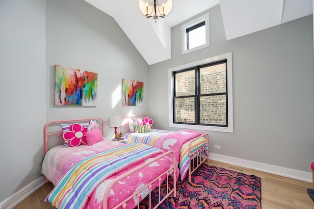 bedroom with vaulted ceiling, visible vents, baseboards, and wood finished floors