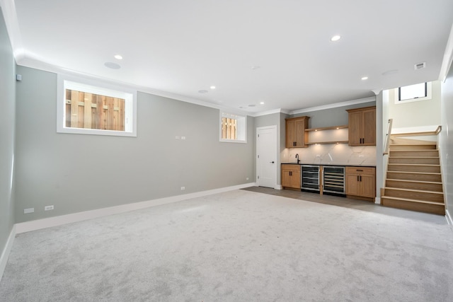 interior space with beverage cooler, indoor wet bar, crown molding, and baseboards