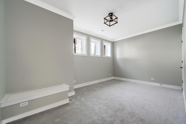 spare room featuring carpet flooring, baseboards, and ornamental molding