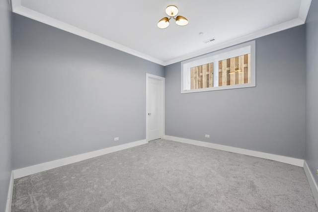 carpeted spare room with visible vents, baseboards, and ornamental molding