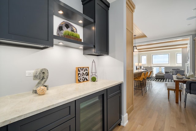 kitchen featuring open floor plan, beverage cooler, and light wood-type flooring