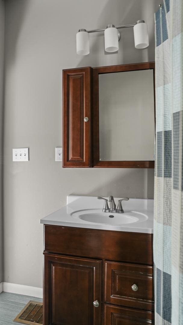 bathroom featuring wood finished floors, vanity, and baseboards