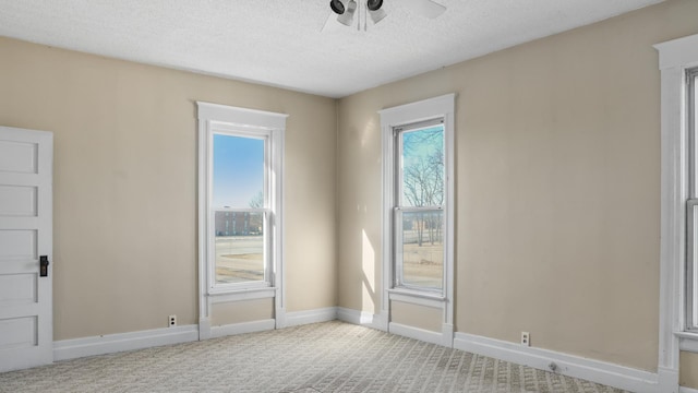 spare room with a ceiling fan, a textured ceiling, baseboards, and carpet flooring