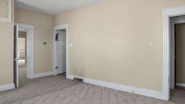 unfurnished bedroom featuring carpet, a textured ceiling, and baseboards