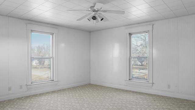 carpeted empty room featuring a ceiling fan