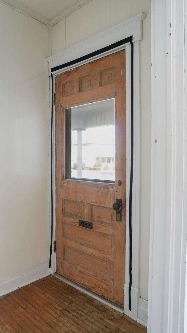 doorway featuring dark wood finished floors and baseboards