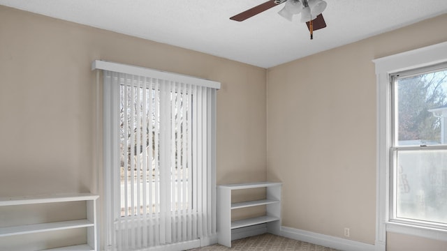 interior space featuring carpet floors, baseboards, and a ceiling fan