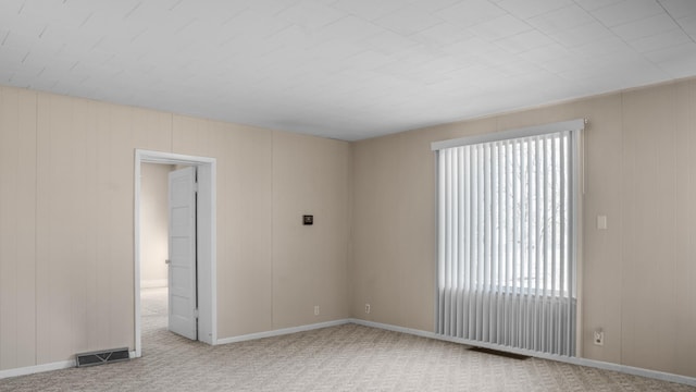 carpeted spare room with baseboards and visible vents