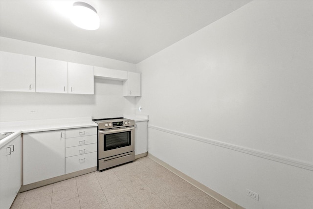 kitchen with electric range and white cabinetry