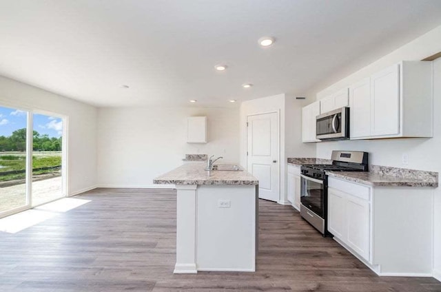 kitchen with white cabinetry, hardwood / wood-style floors, and stainless steel appliances