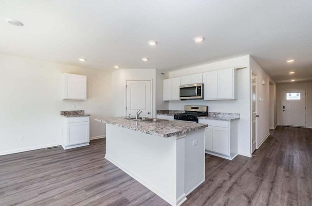 kitchen with a kitchen island with sink, dark wood-type flooring, white cabinets, sink, and appliances with stainless steel finishes