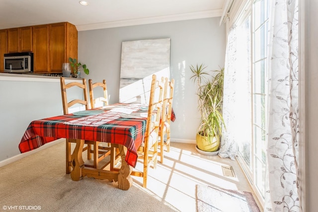 carpeted dining space featuring ornamental molding