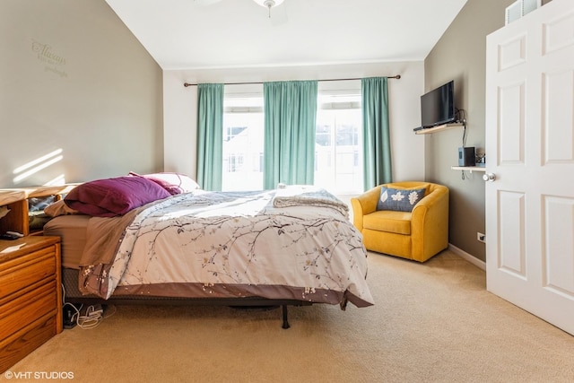 bedroom featuring light carpet, vaulted ceiling, and ceiling fan