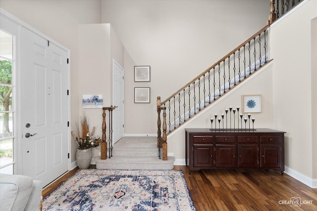 foyer entrance featuring a healthy amount of sunlight, dark hardwood / wood-style flooring, and a high ceiling