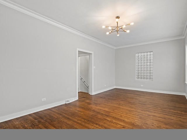 empty room with dark wood-type flooring, a chandelier, and ornamental molding