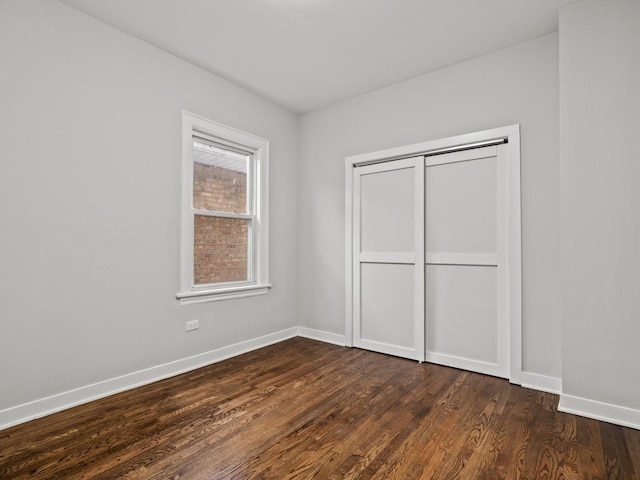 unfurnished bedroom with a closet and dark hardwood / wood-style flooring