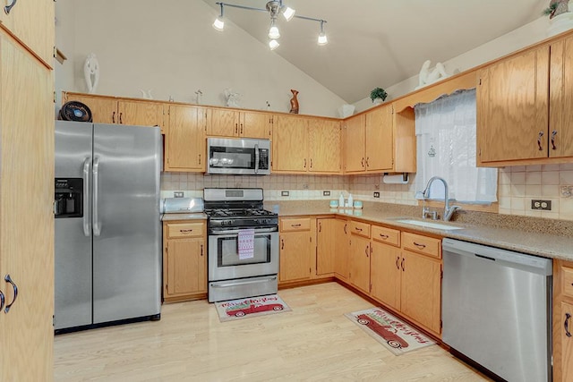 kitchen with high vaulted ceiling, sink, light hardwood / wood-style flooring, decorative backsplash, and appliances with stainless steel finishes