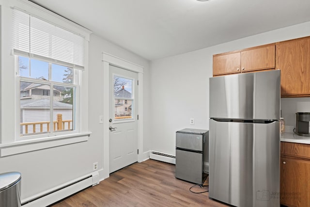 kitchen featuring a baseboard radiator, stainless steel refrigerator, and light hardwood / wood-style floors