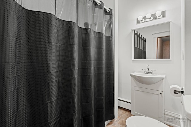 bathroom with walk in shower, vanity, toilet, and baseboard heating