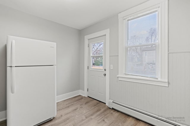 entryway with light wood-type flooring, plenty of natural light, and baseboard heating