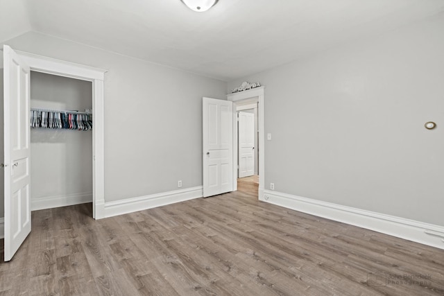 unfurnished bedroom with a closet and light hardwood / wood-style floors