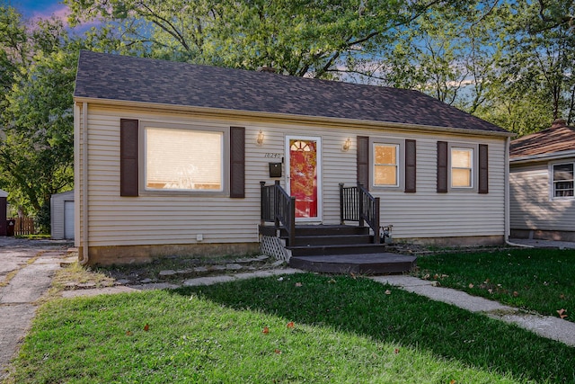 view of front of house featuring an outbuilding and a yard