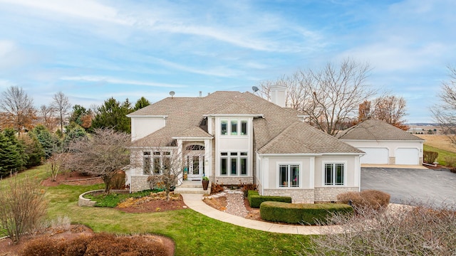 back of property with a garage and a yard