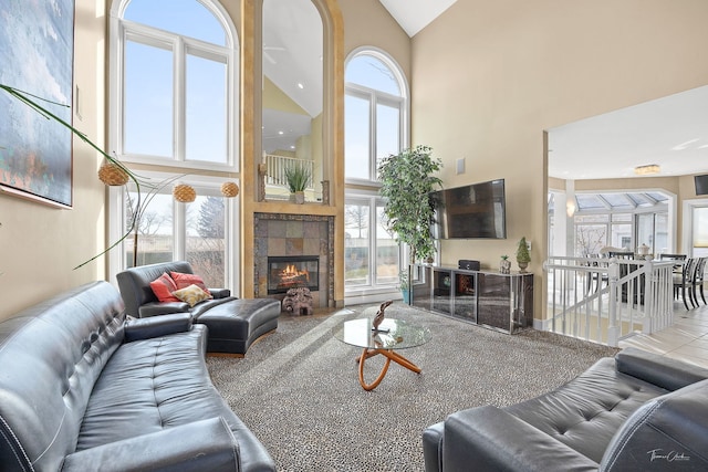 living room with a fireplace, high vaulted ceiling, and a healthy amount of sunlight