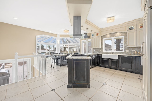 kitchen with backsplash, light tile patterned floors, sink, and cream cabinets