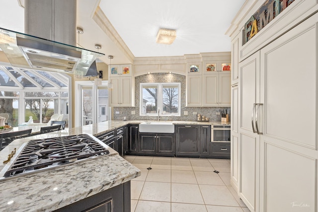 kitchen with sink, stainless steel gas cooktop, crown molding, island range hood, and light tile patterned floors