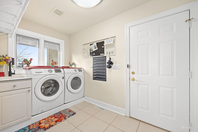 clothes washing area with cabinets, independent washer and dryer, sink, and light tile patterned floors