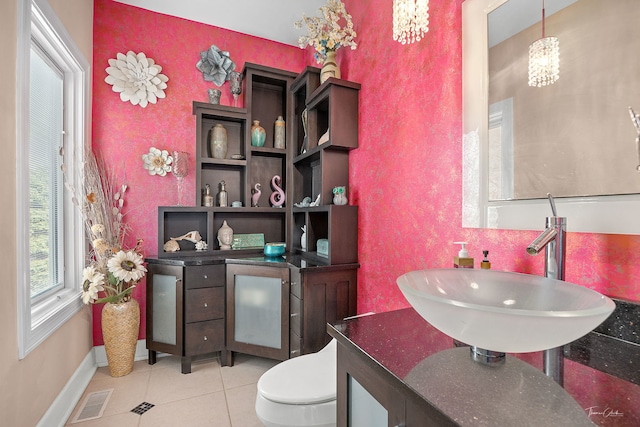 bathroom featuring tile patterned flooring, visible vents, toilet, baseboards, and a chandelier