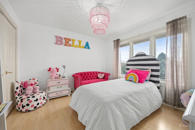 bedroom featuring a closet, wood-type flooring, and a notable chandelier