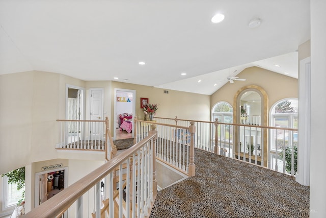 hallway with lofted ceiling, an upstairs landing, and recessed lighting