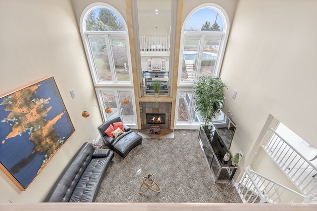 living room with a fireplace and a high ceiling