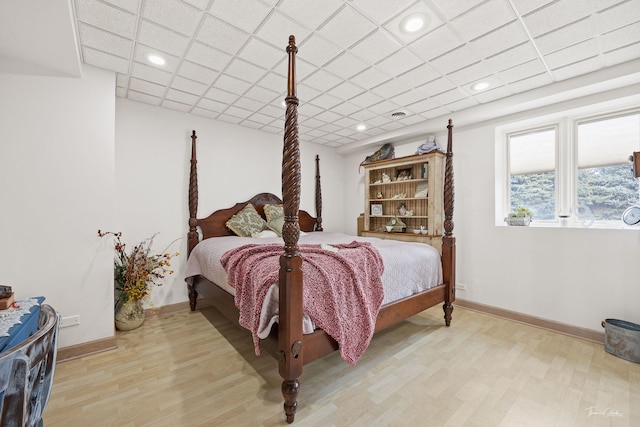 bedroom featuring a paneled ceiling and light hardwood / wood-style floors