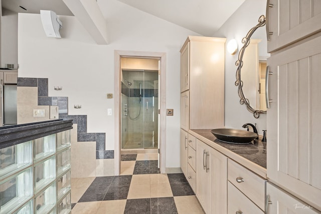 bathroom with vaulted ceiling, a shower stall, tile patterned floors, and vanity