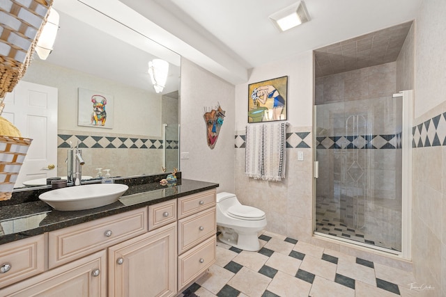 bathroom with vanity, toilet, an enclosed shower, and tile walls