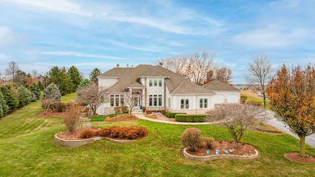 back of house featuring a garage, a lawn, and a chimney