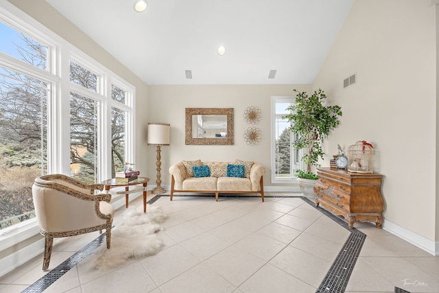 living area with vaulted ceiling, a wealth of natural light, and light tile patterned flooring