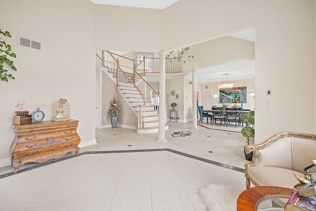 tiled foyer with ornate columns and a chandelier