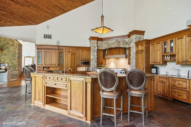 kitchen featuring light stone countertops, wood ceiling, decorative light fixtures, high vaulted ceiling, and a kitchen island