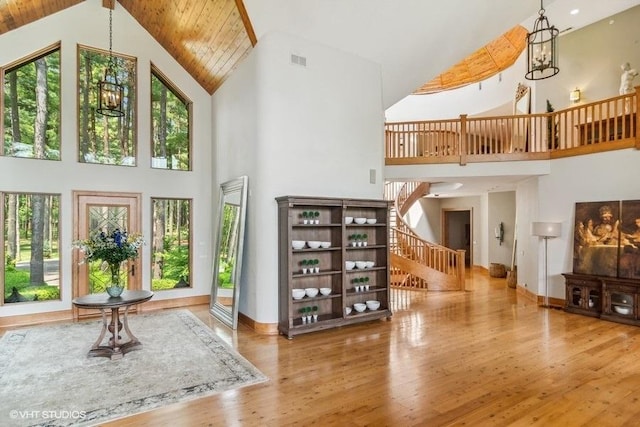 interior space with wood ceiling, high vaulted ceiling, wood-type flooring, and a notable chandelier