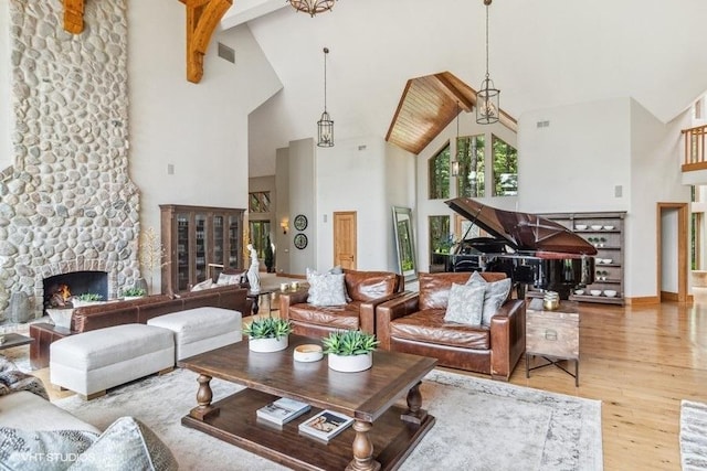 living room with a fireplace, high vaulted ceiling, hardwood / wood-style floors, and beamed ceiling