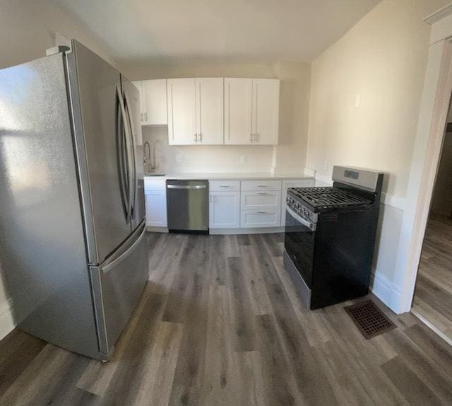 kitchen with white cabinetry, dark wood-type flooring, and appliances with stainless steel finishes