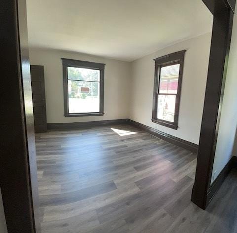 empty room with plenty of natural light and dark wood-type flooring