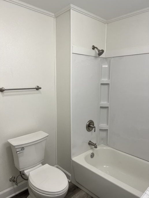 bathroom featuring toilet, ornamental molding, and shower / washtub combination