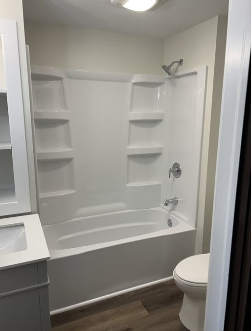 full bathroom featuring hardwood / wood-style floors, vanity, toilet, and shower / bathing tub combination