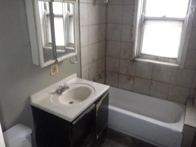 full bathroom with vanity, tiled shower / bath, and toilet