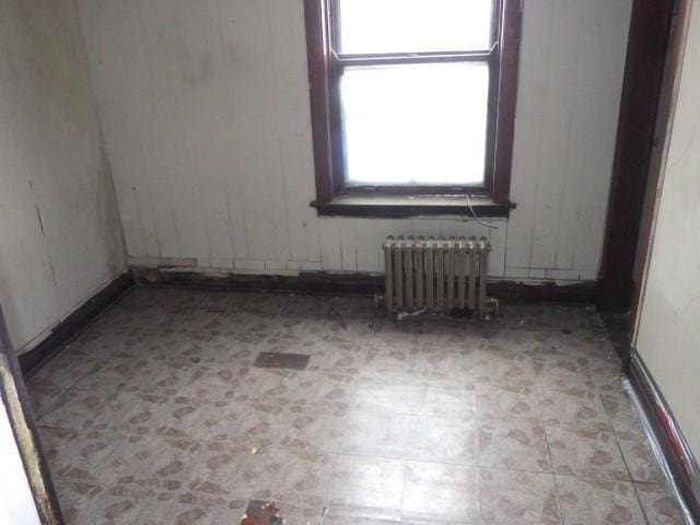 unfurnished room featuring radiator